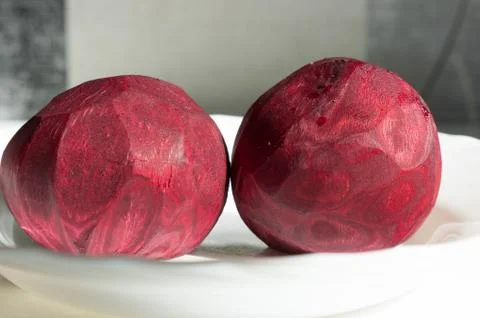 Two peeled beets that lying on the white plate. Stock Photos