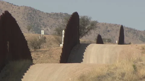 Two people approaching US and Mexico border fence in Nogales, Arizona Video stock 130941752