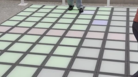 Two people are dancing on a dance floor with a colorful pattern Stock Footage 282297308