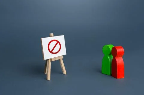 Two people are looking at an easel with the prohibition symbol NO. No acces.. Stock Photos