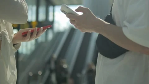 Two people are looking at their cell phones in a public place Video stock 311159414