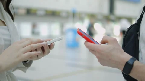 Two people are looking at their phones in a public place Stock Footage 311620893
