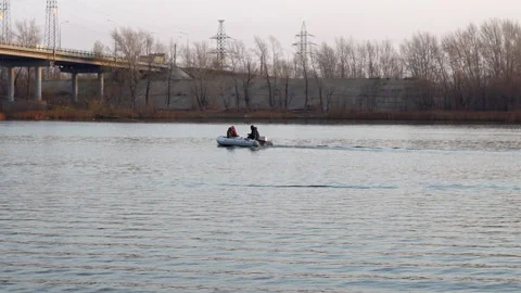 Two people are sailing on an inflatable motor boat on the river, lake. Fishermen Video stock 142590831