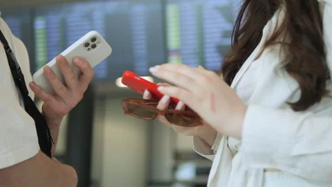 Two people are standing next to each other, one of them holding a cell phone Stock Footage 311384694
