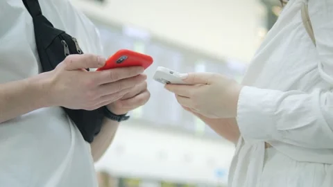 Two people are talking on their cell phones in a public place Stock Footage 311623655