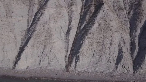 Two people are walking down stairs and seat at a beach near the cliffs Stock Footage 86902592