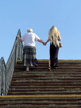 Two people ascend stone steps together, hand in hand Stock Photos