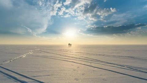 The two people with backpacks going trough the snow field Stock Footage 189405227