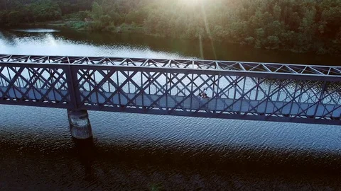 Two people biking on an old iron bridge Video stock 130084649