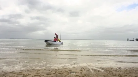 Two people on a boat on beach Stock-Footage 79715089