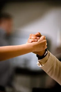 Two people clasping hands in a strong grip, symbolizing teamwork, trust, and Stock Photos