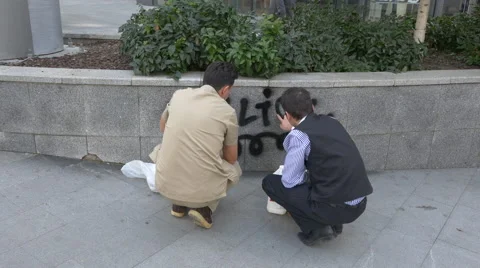 Two people cleaning up a graffiti in Bucharest Video stock 57965816