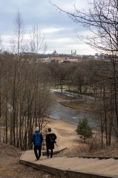 Two people climbing down hill on wooden stairs in Vilnius, Lithuania Stock Photos