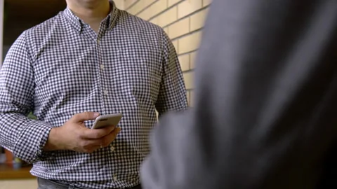 Two people communicate. The man is interviewing. Man with smartphone with Stock Footage 163305676