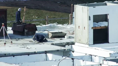 Two people construction workers laboring on building foundation in winter. One Stockbeeldmateriaal 339865990