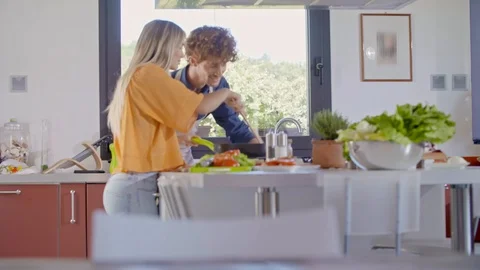 Two people cooking and preparing meal at home. Young couple cooking at home Stock-Footage 127961149