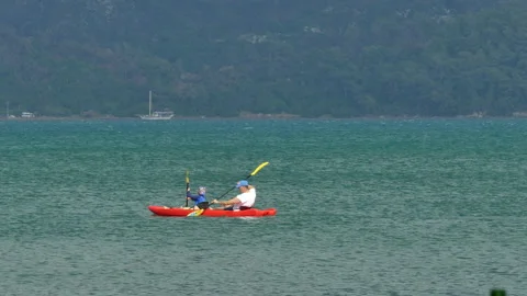 Two people cruising in a small red canoe 库存影片 211846487
