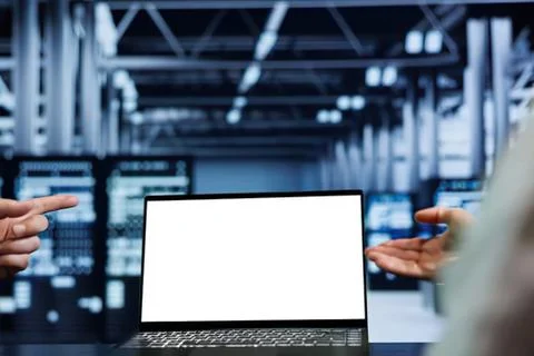 Two people discussing laptop in server room Stock Photos