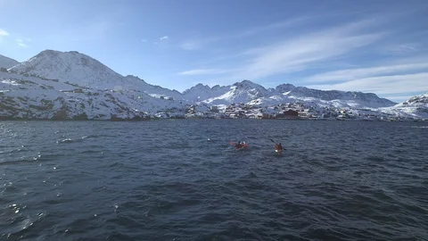 Two people dragging a kayak on a Arctic beach, Greenland Stock Footage 104191319