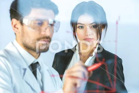The two people draw the graph at the virtual screen Stock Photos
