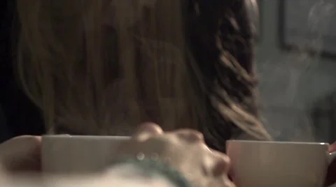 Two people drinking from steaming cups in a coffee shop Stock Footage 59006527