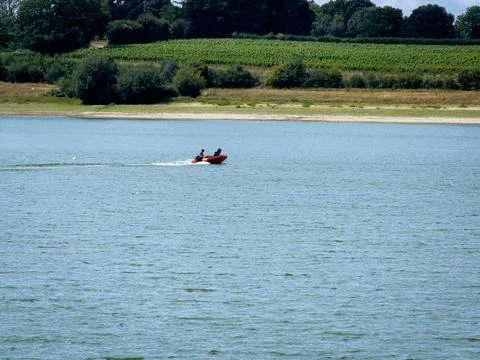 Two people driving small red dinghy 4K Stock-Fotos