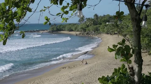 Two people on empty beach in Rincon Puerto Rico on sunny day Stock Footage 157397668