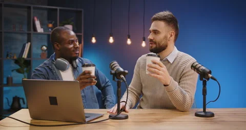 Two people enjoying beverages while recording a podcast with microphones Stock Footage 328973374