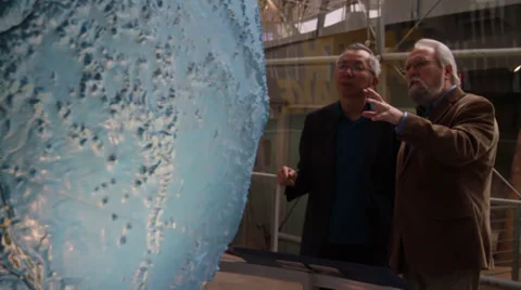 Two people exchange information while looking at the globe Stock Footage 36157953