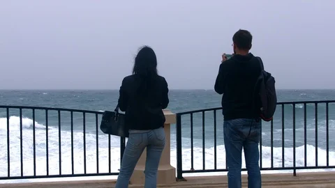 Two people fillming big waves at Sliema embankment. Malta 库存影片 89134842