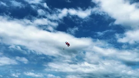 Two people fly on a parachute over a sky-blue sea on two domes towed by a boat Stock Footage 316702710