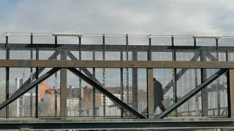 Two people go through an elevated metal walkway Stock Footage 101728285
