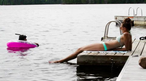 Two People Hanging Out By Dock and Swimming Stock Footage 66563275