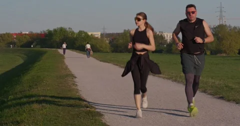 Two people jogging on paved park path 库存影片 332550772
