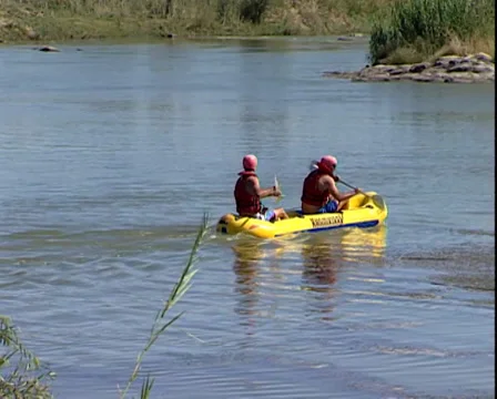 Two people kayaking across a river Stock Footage 34315204