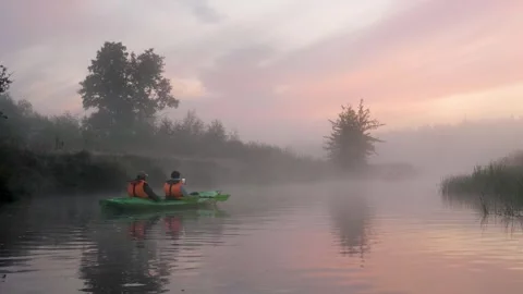Two people kayaking on a misty river at sunrise Stock Footage 341965562