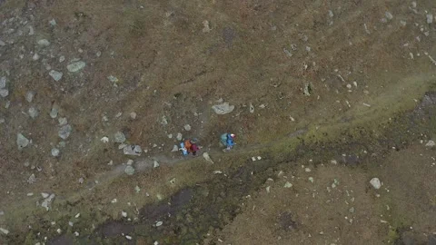 Two people with large backpacks went out to a stormy mountain river Stock Footage 259792968