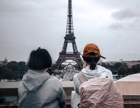 Two people looking at the Eiffel Tower in Paris, France. Stock Photos