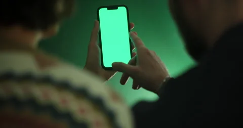 Two people operate a smartphone with a green screen Vidéo 262660853