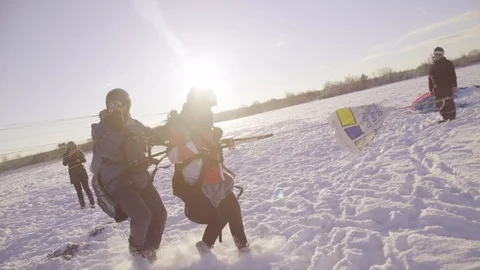 Two people paraglide on a snowy field in Latvia. 動画素材 113687578