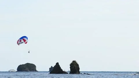 Two people parasailing in Manuel Antonio, Costa Rica. Speed boat pulling a Vídeo Stock 168342801