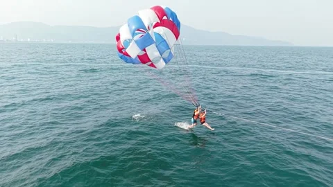 Two people parasailing over ocean waters, enjoying an exhilarating adventure and Video stock 333375725
