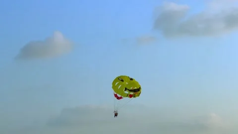 Two people parasailing with a parachute pulled by a boat on vacation at sunset Vídeos de archivo 204732739