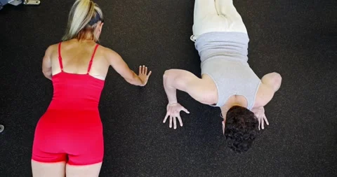 Two People Performing Push-Ups in a Gym Vídeo Stock 323777314
