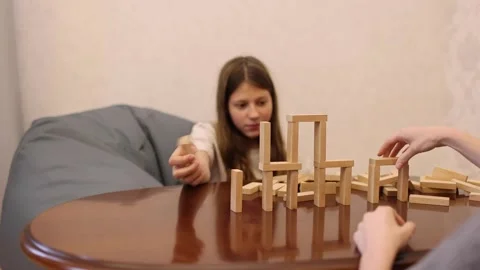 Two people playing a block stacking game at a table Stock Footage 278889828