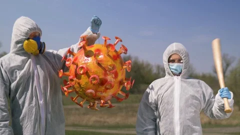 Two people pose with an orange coronavirus pinata in 4K Stock Footage 129543041