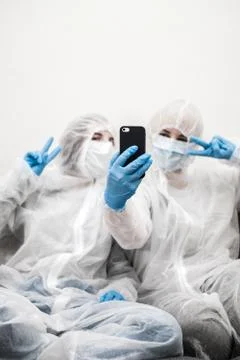 Two people in protective white translucent suit, blue rubber gloves, medical Foto stock