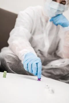 Two people in protective white translucent suit, blue rubber gloves, medical Stock Photos