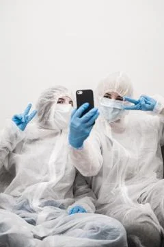 Two people in protective white translucent suit, blue rubber gloves, medical Stock-Fotos
