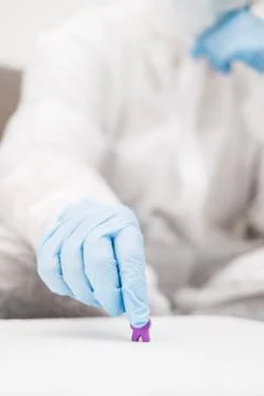 Two people in protective white translucent suit, blue rubber gloves, medical Stock Photos